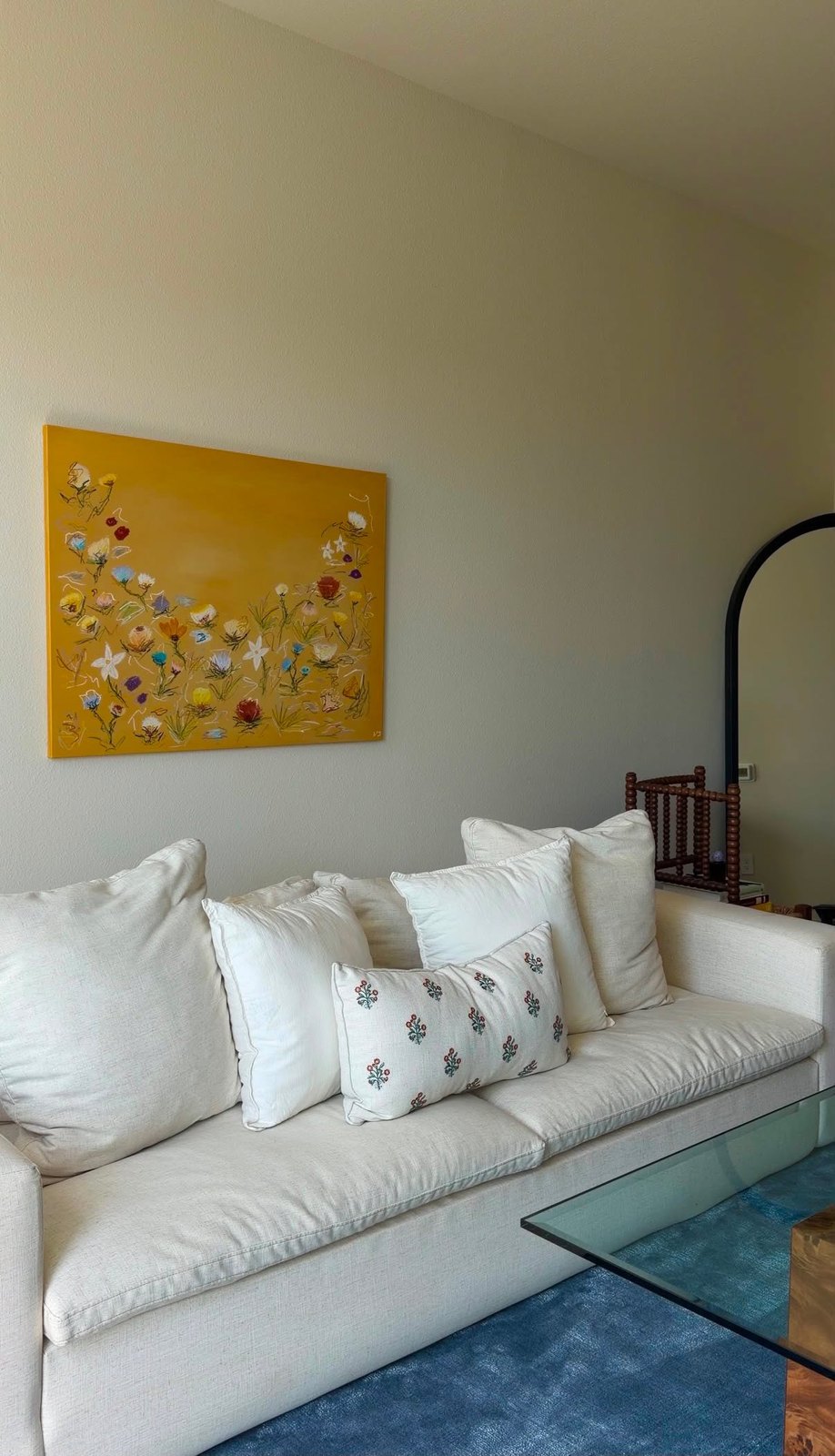 A marigold floral canvas hung above a white linen sofa in a client's living room