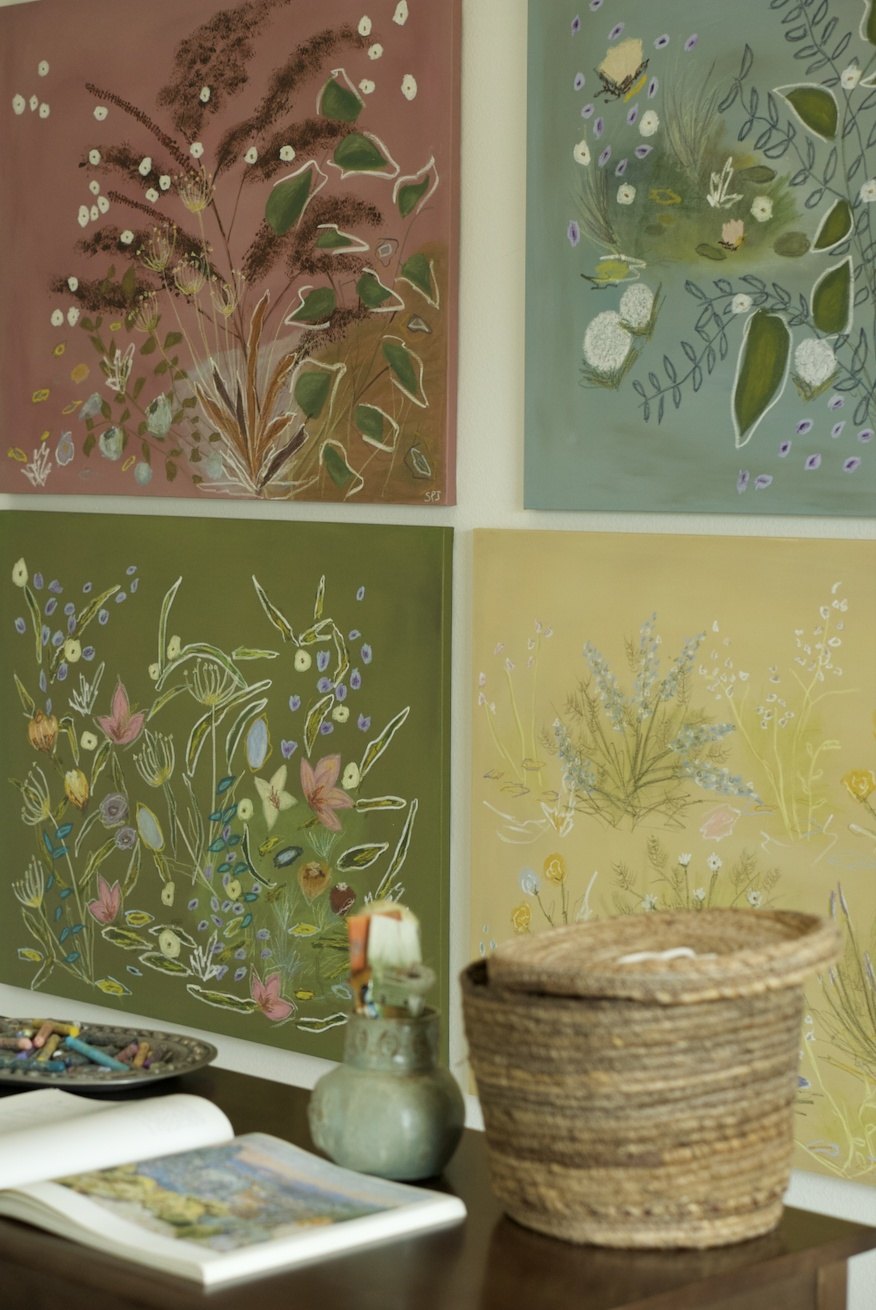 Four SPJ Atelier canvases hung together on a studio wall above a table of pastels