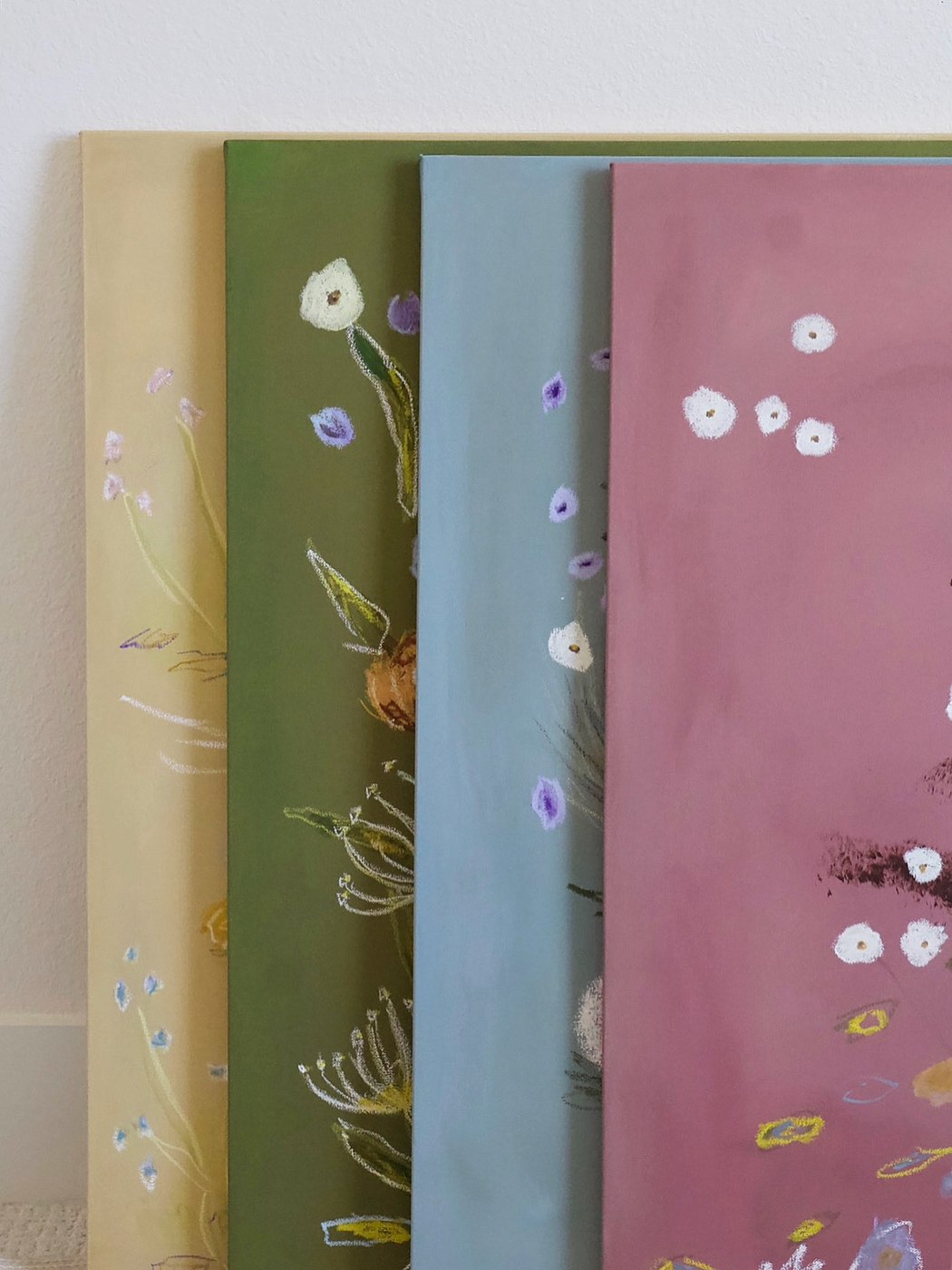 Four finished canvases leaning against the wall, seen edge on